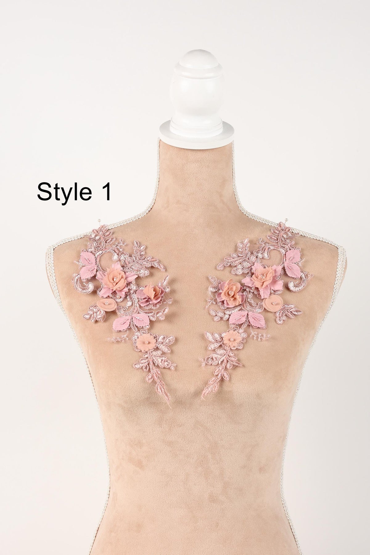 A mannequin with a floral design on its shoulders, featuring pink flowers and leaves.