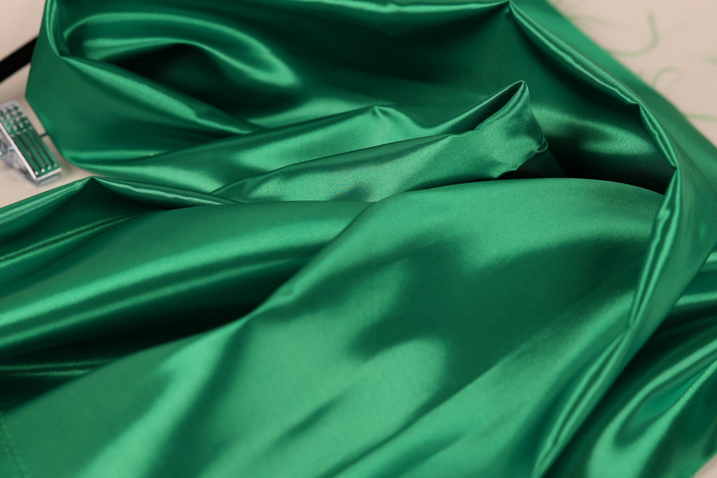 a close-up view of a shiny, green satin fabric.