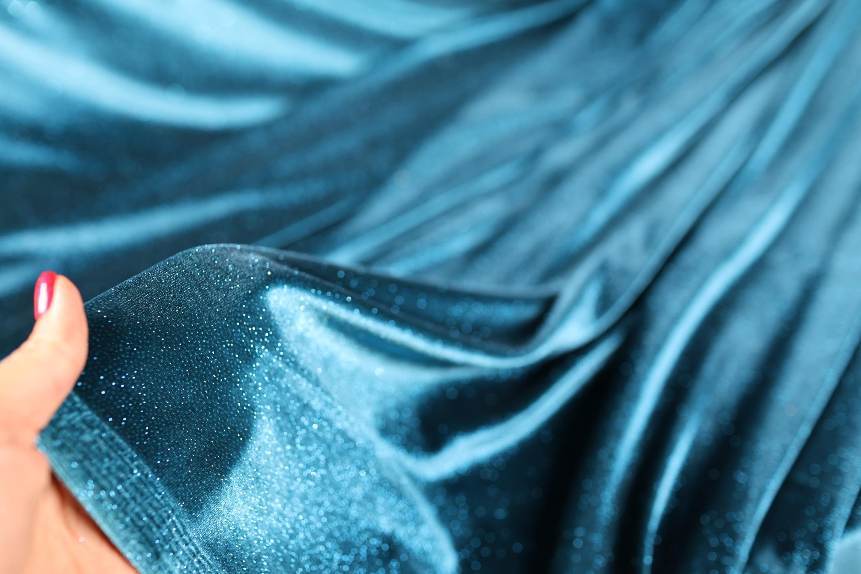 a woman's hand holding a blue cloth