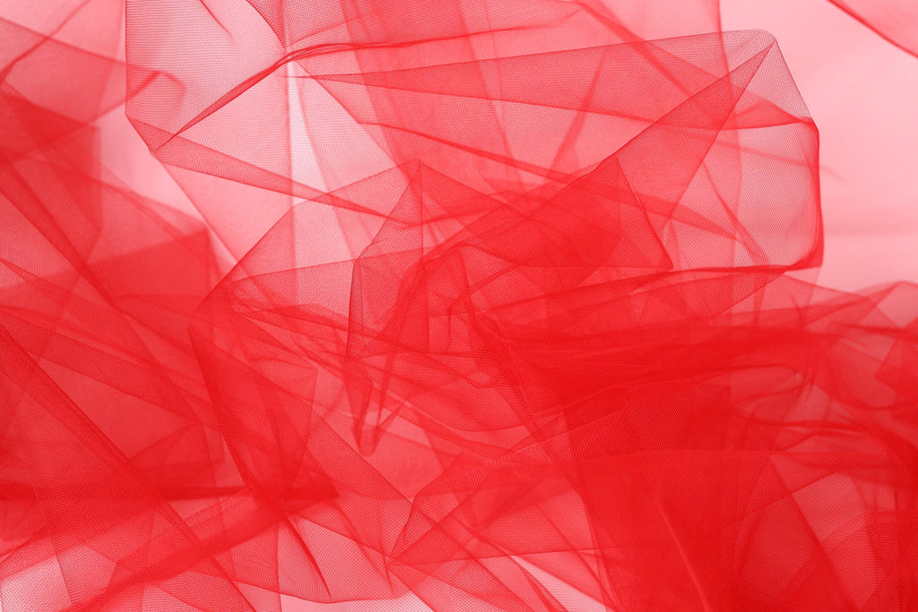 The image is a close-up of a red, translucent fabric with a textured, layered appearance.
