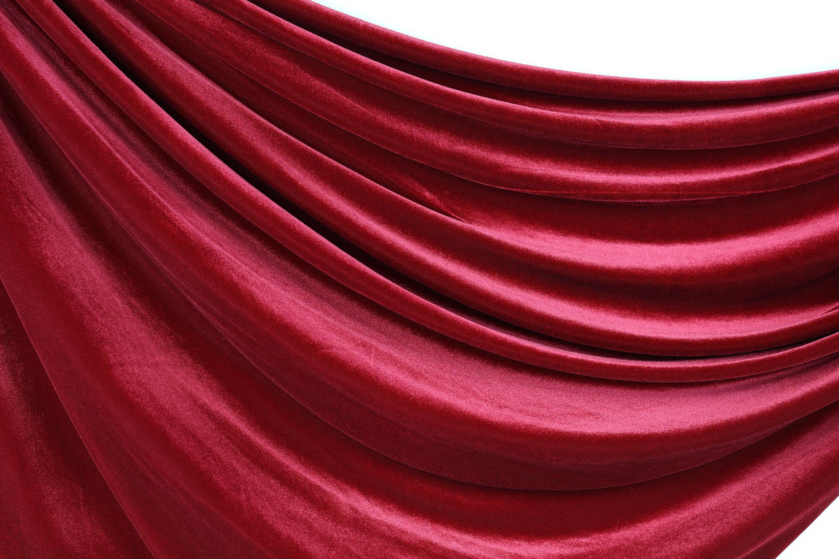 a close-up view of a red velvet fabric, with its smooth and shiny texture visible.