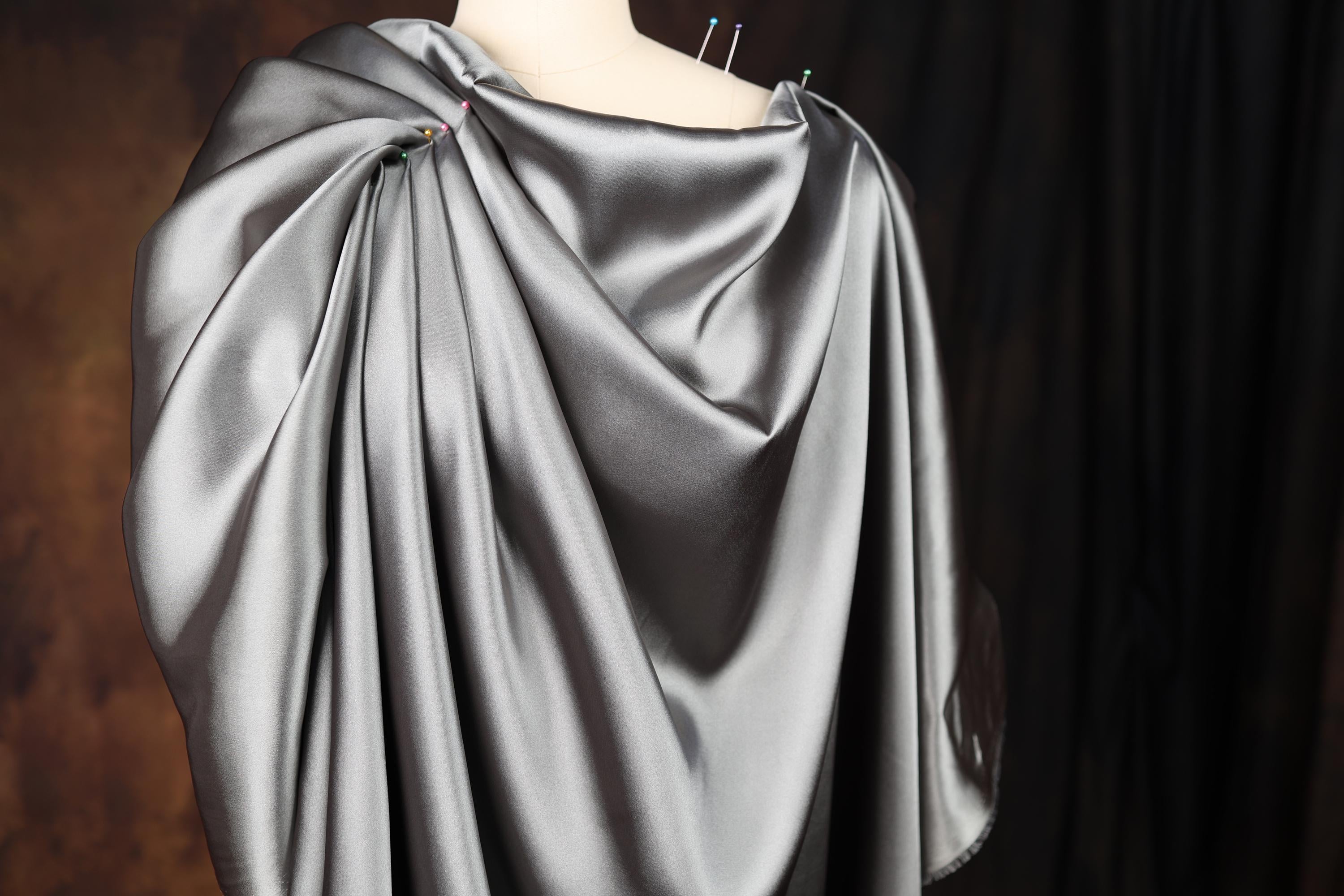 a dress on a mannequin wearing a silver cape