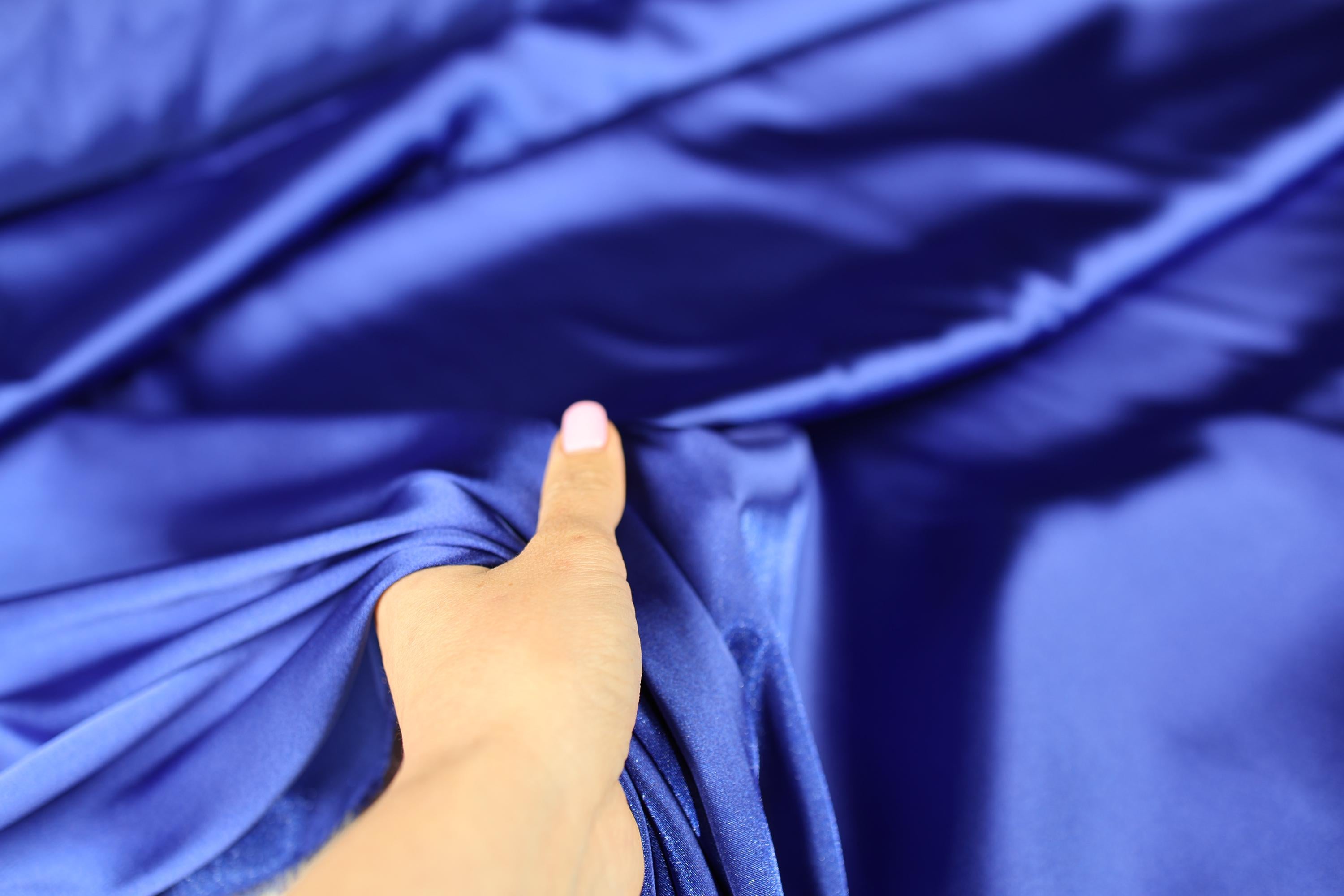 a person's hand on a blue cloth