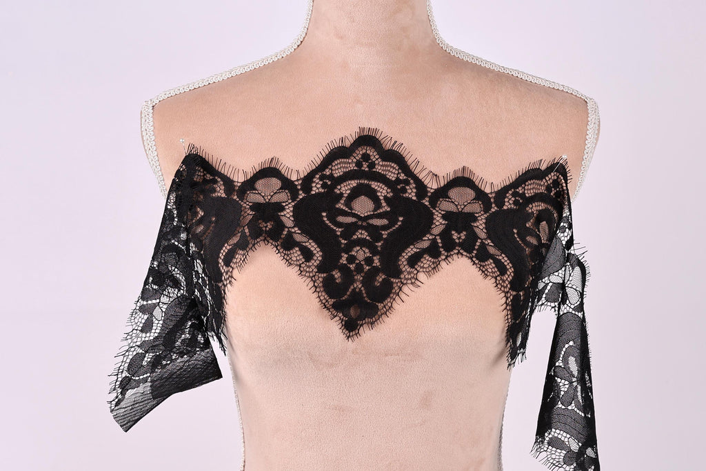 A mannequin wearing a black lace overlay on its chest area.