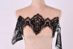 A mannequin wearing a black lace overlay on its chest area.