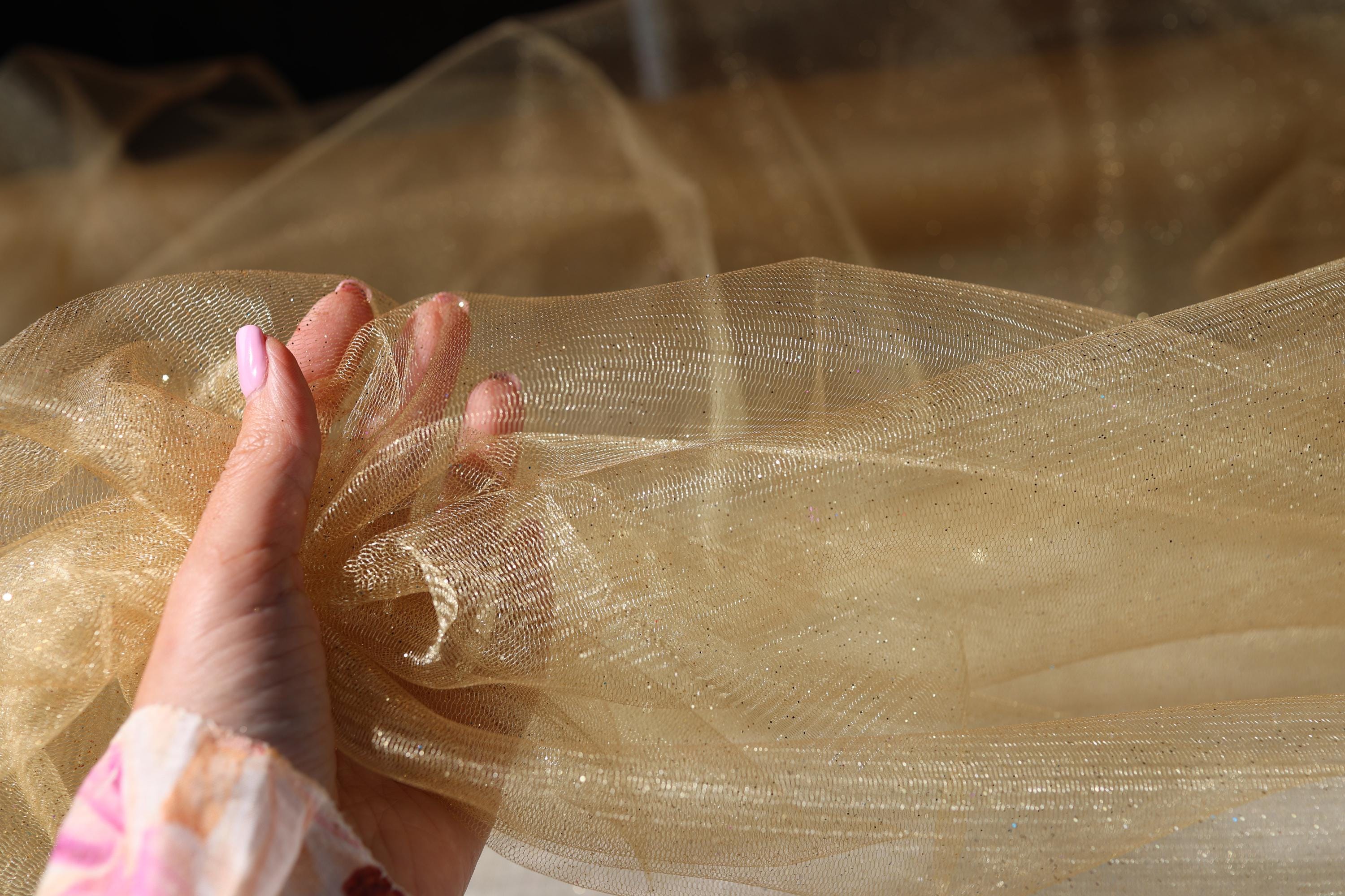 a woman's hand holding a piece of tulle