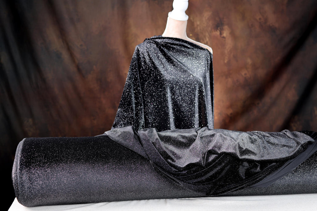 a mannequin dressed in a black dress with a black cape