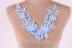 A close-up of a mannequin wearing a necklace with a floral design in blue and white colors.