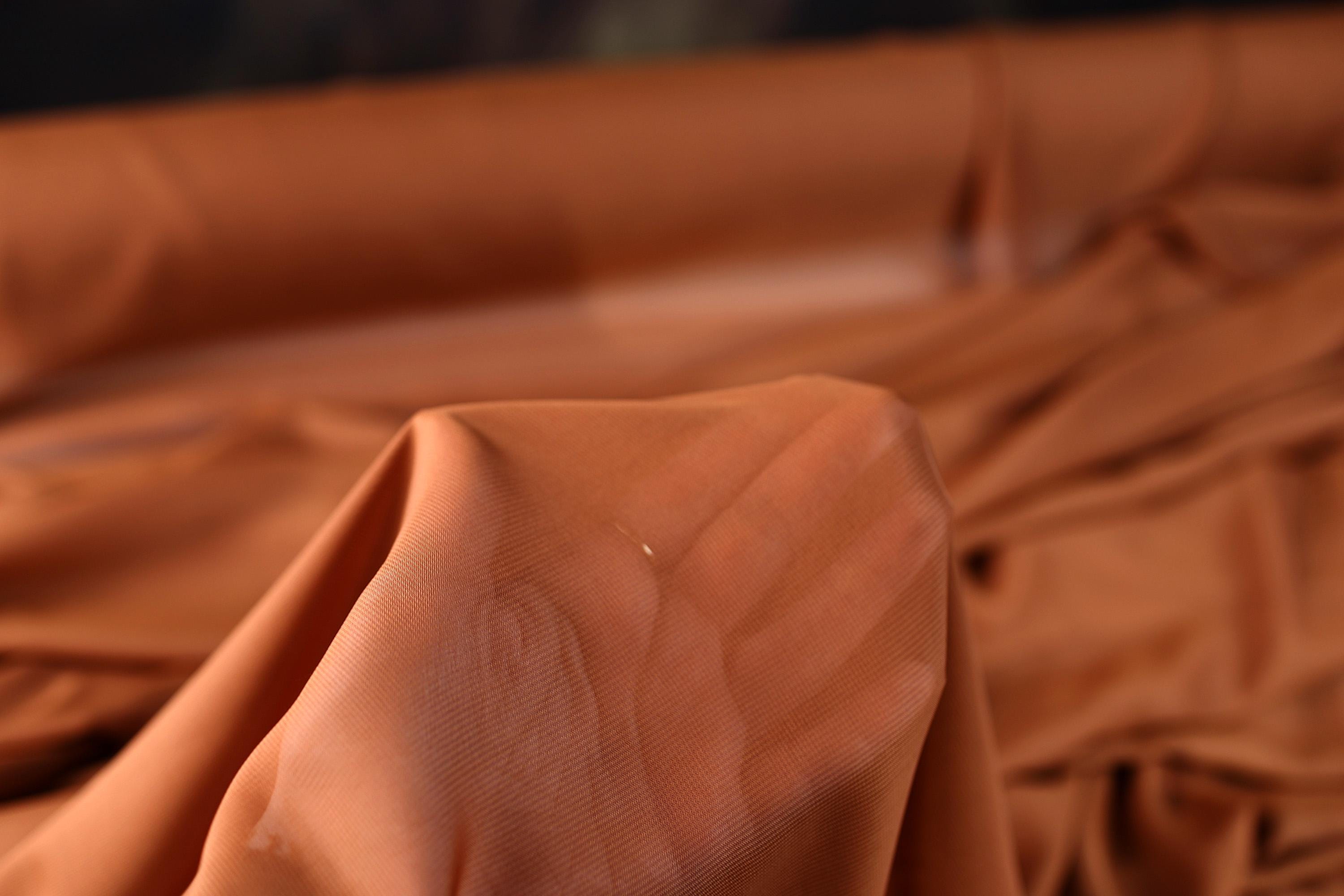 a close up of a bed with a brown comforter