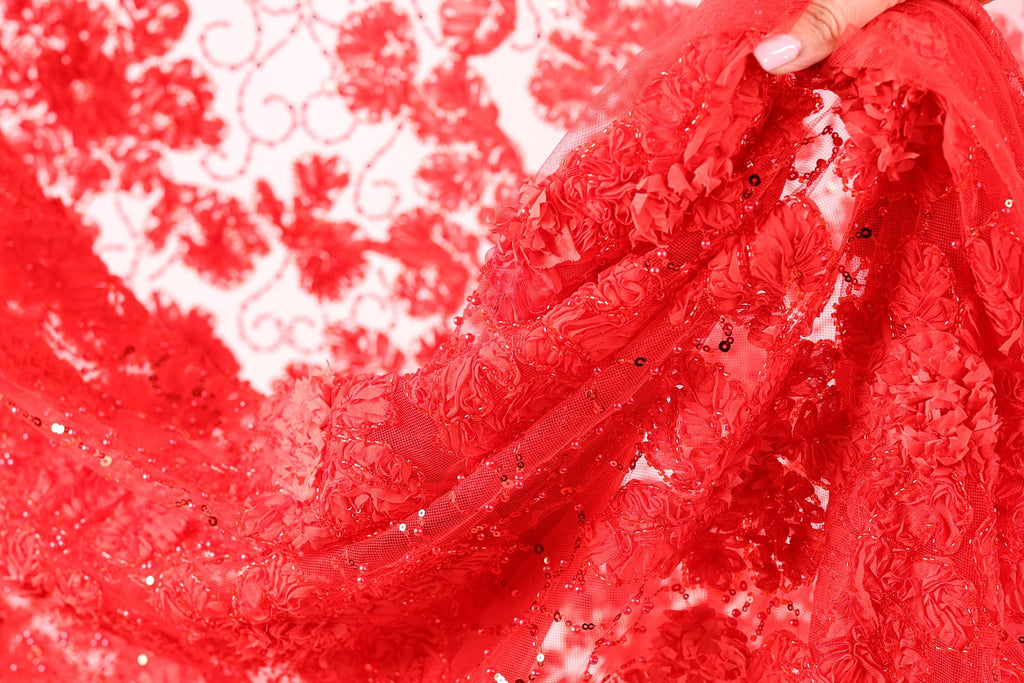 A close-up view of a red, intricately designed fabric with a floral pattern.