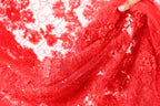 A close-up view of a red, intricately designed fabric with a floral pattern.