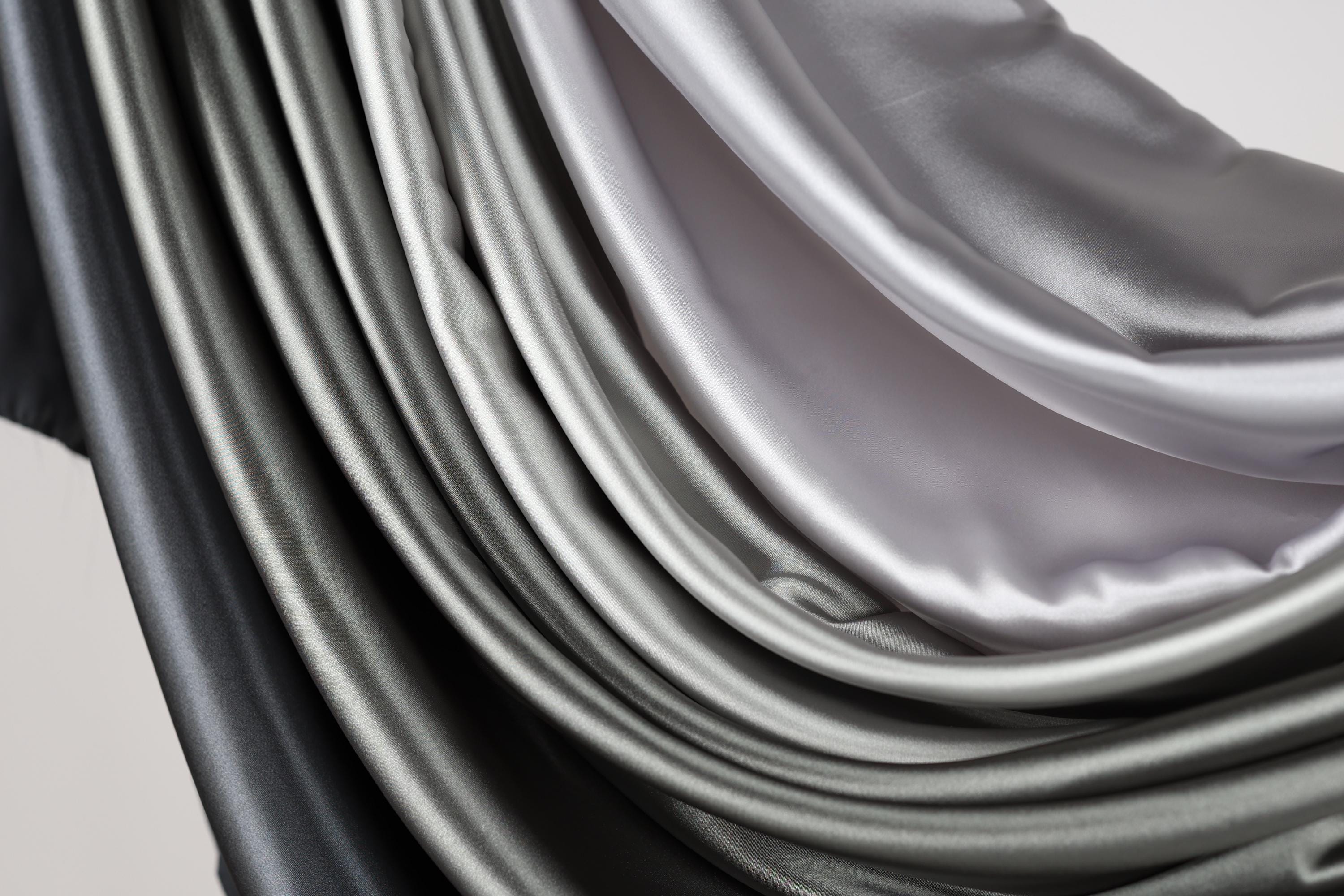 a close-up view of a fabric with a gradient of gray and black colors, creating a visually striking and textured appearance.