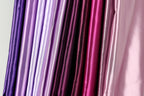 A collection of colorful fabric swatches in various shades of purple, pink, and red.