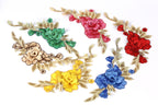 a variety of colorful floral embroidery pieces, including red, green, yellow, blue, and brown flowers with leaves.