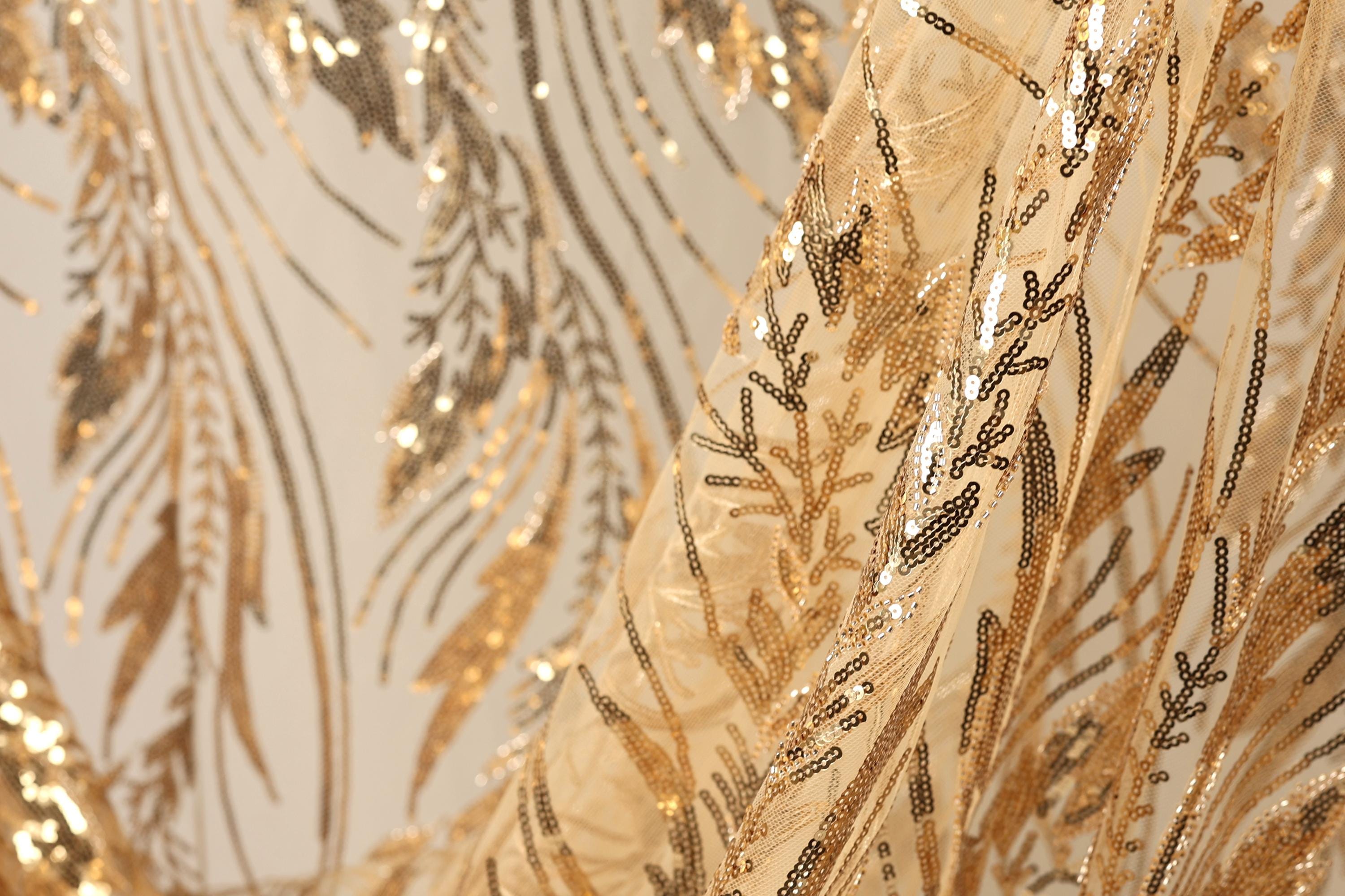 a close-up view of a fabric with a gold and black sequin pattern, creating a visually striking and intricate design.