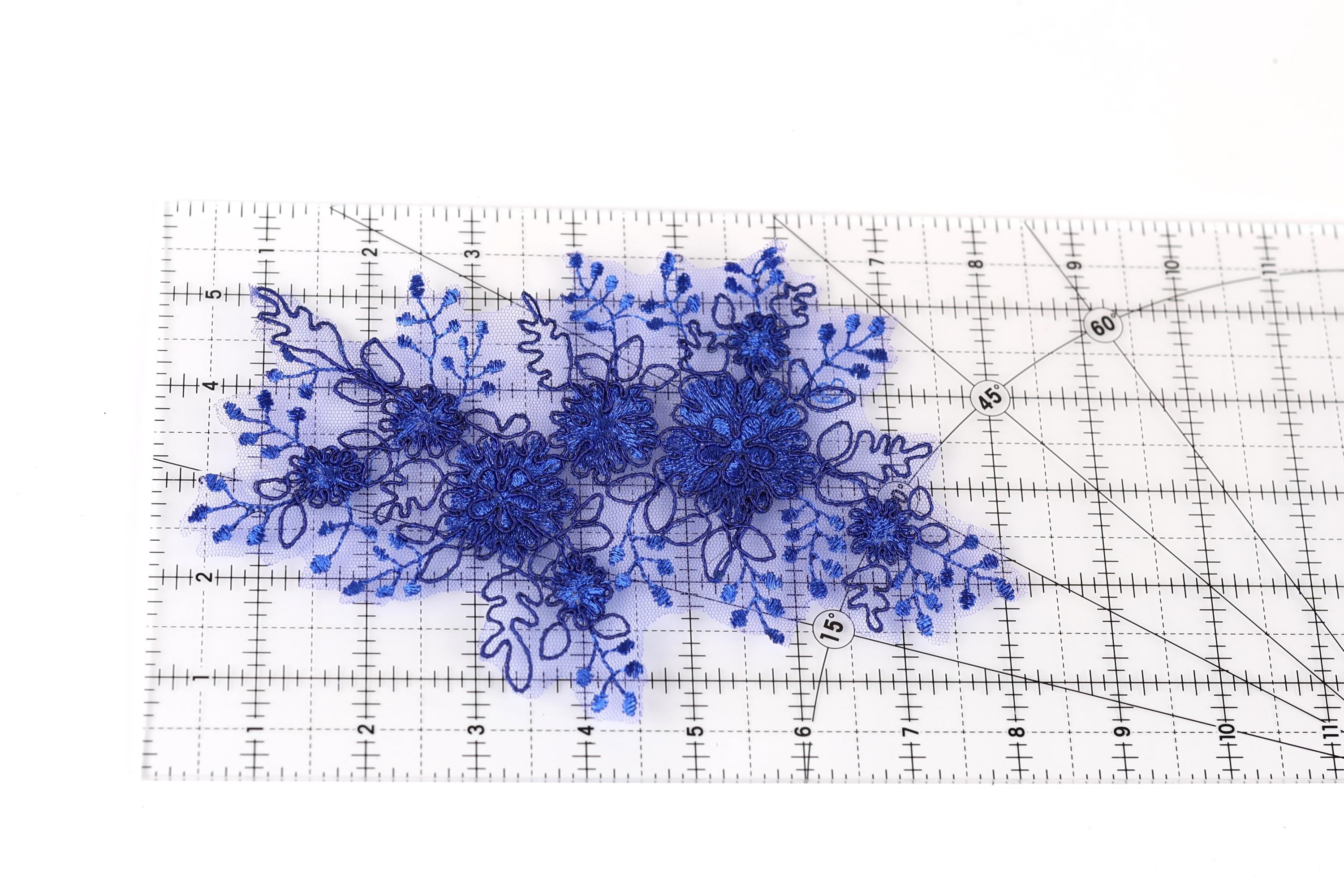 a clear ruler with blue floral embroidery designs placed on it.