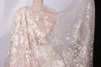 A close-up view of a delicate, lace-like fabric with a flowing, draped appearance.