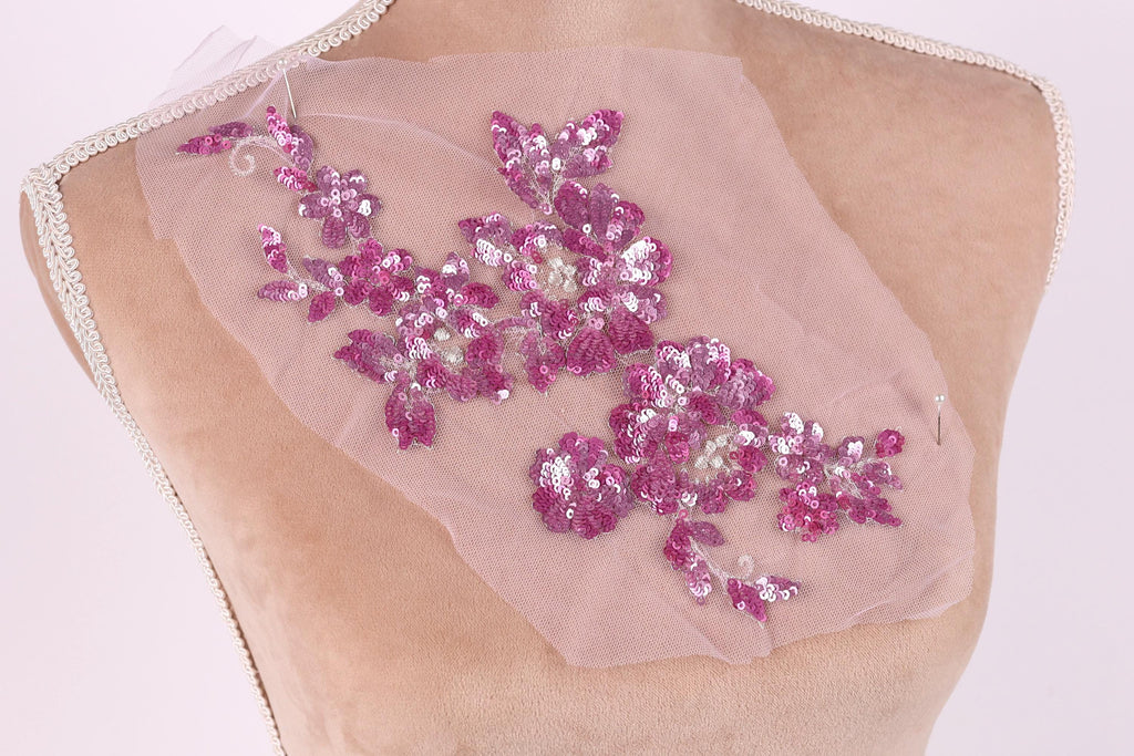 a mannequin torso with a pink sequin flower design on the back.