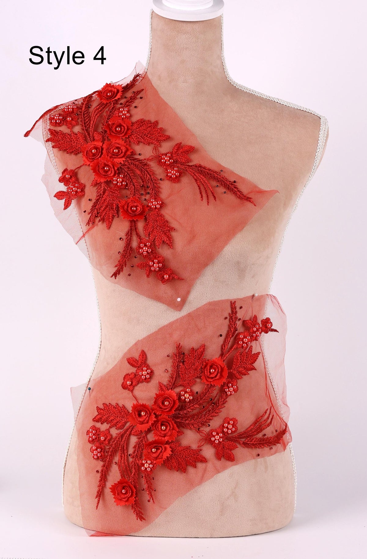 A mannequin wearing a red floral dress with a sheer overlay.