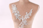 A mannequin torso with a delicate, intricate lace design on the bust area, featuring a floral pattern.