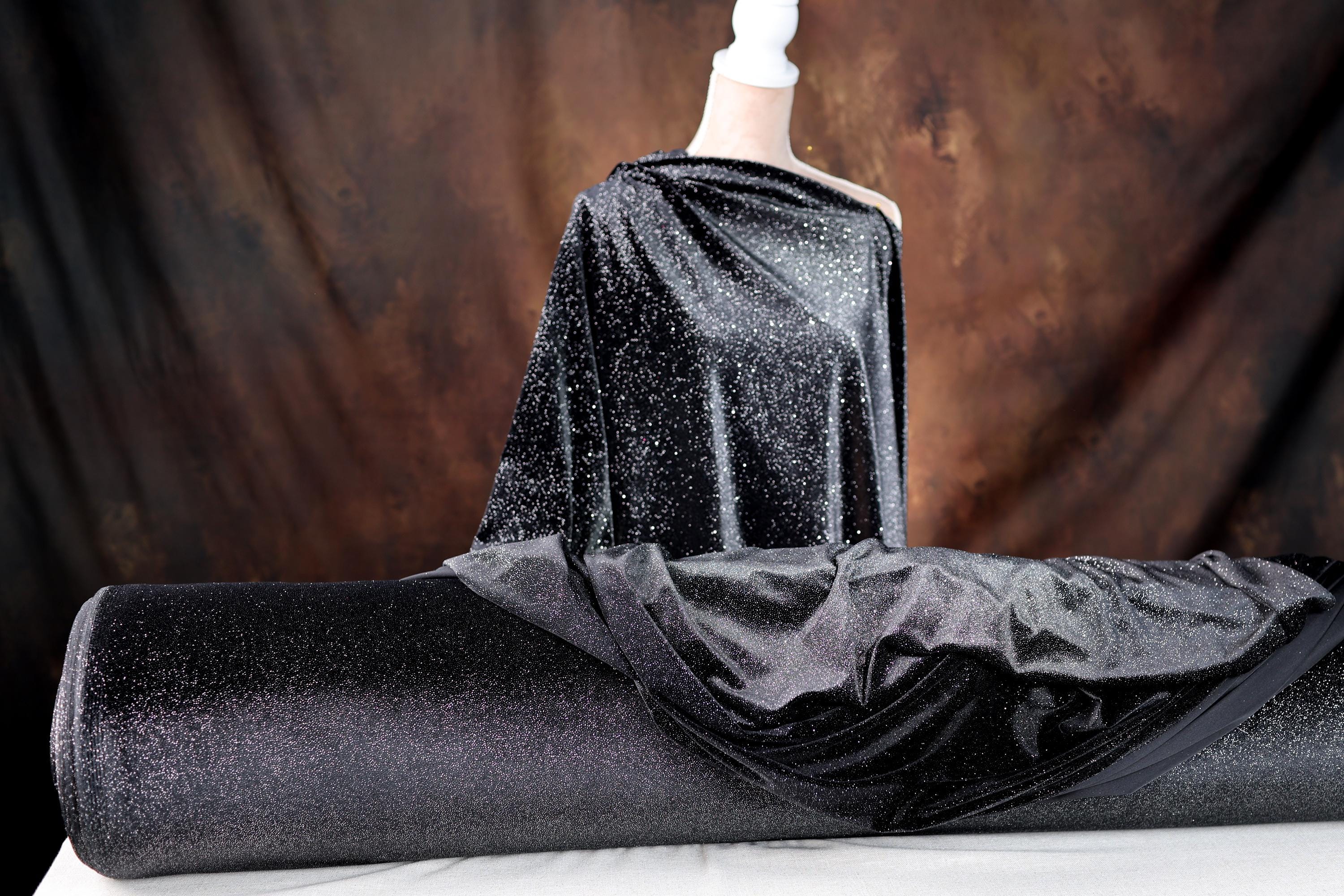 a mannequin dressed in a black dress with a black cape