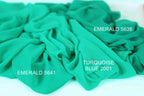a close-up of a crumpled piece of turquoise fabric, with text indicating the color and brand of the fabric.