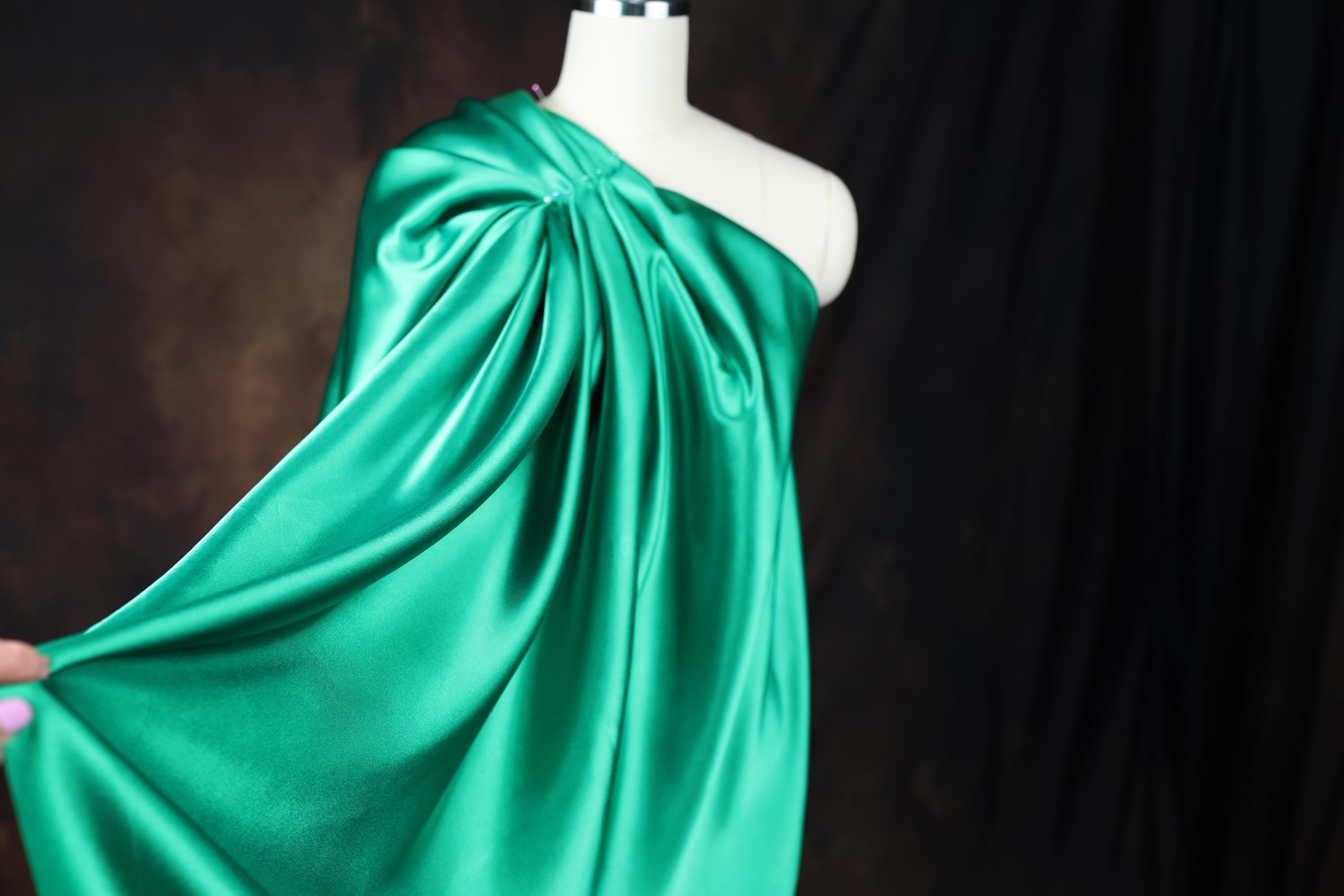 a mannequin dressed in a green cape