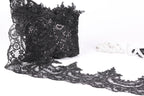 a close-up view of a black lace fabric with intricate patterns and designs, including a lace trim.