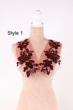 A mannequin wearing a red and black floral-patterned vest with sequin details.