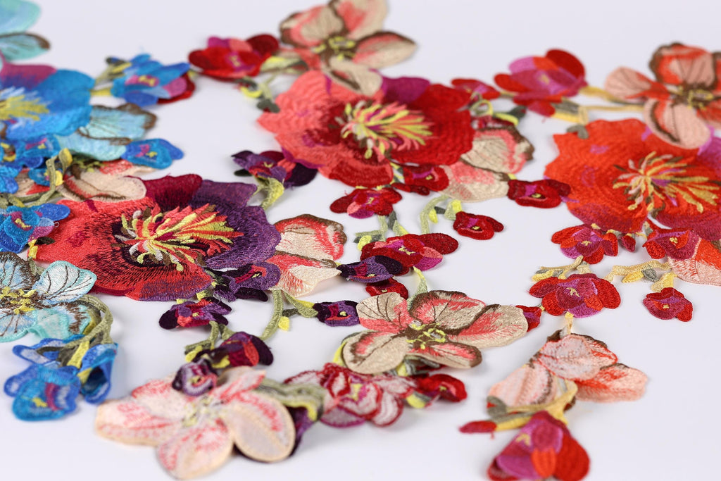 a variety of colorful, intricately embroidered flowers in shades of red, pink, blue, and purple.