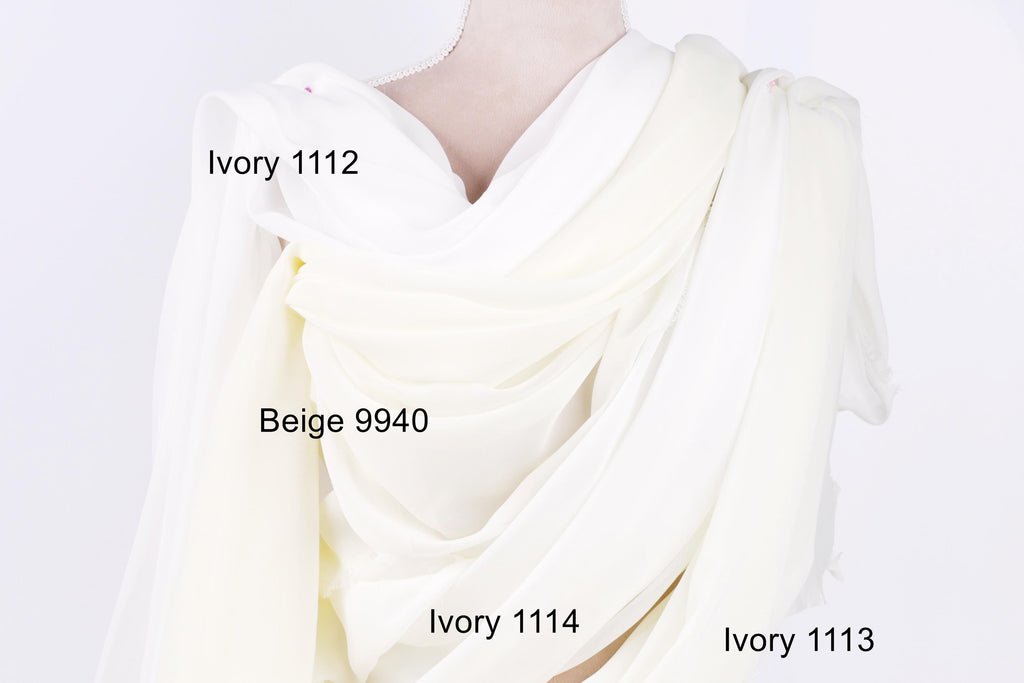 a close-up view of a white fabric, possibly a dress or garment, with three different shades of white visible. The text labels the different shades, indicating their names: Ivory 1112, Beige 9940, and Ivory 1114.