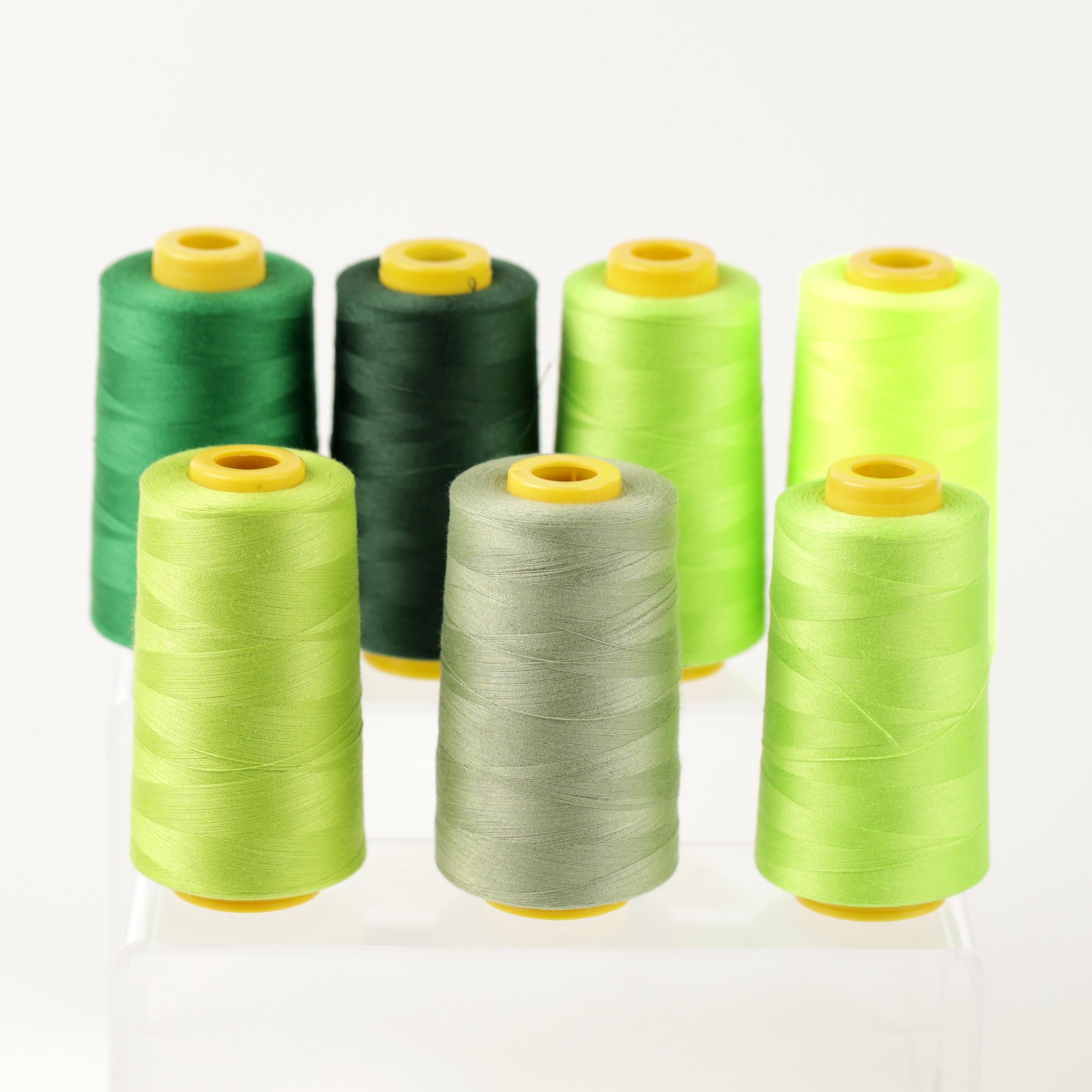 a collection of six spools of thread in various colors, including green, black, and lime green.