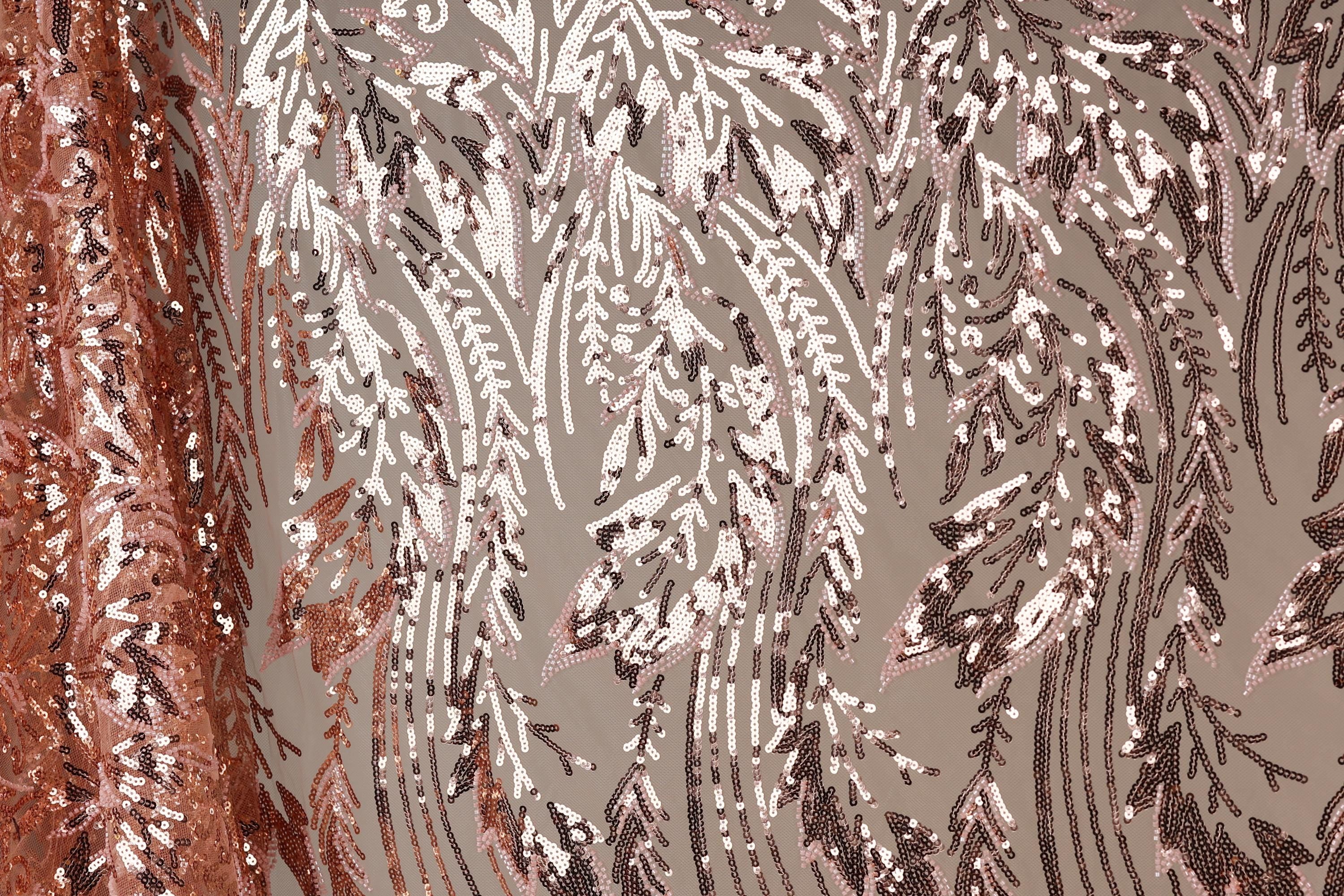 a close-up view of a fabric with a repeating pattern of pink and brown sequin designs. The pattern appears to be a floral or leaf-like design, with the sequins arranged in a way that creates a sense of movement and texture. The fabric is predominantly pink and brown, with the pink sequins standing out against the brown background. The image does not contain any text or other discernible objects, and the focus is solely on the intricate and visually appealing pattern of the sequin fabric.