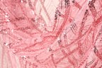 A close-up view of a pink sequin fabric, with a textured and intricate pattern of sequins and threads.