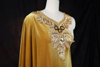 A gold dress with a draped, flowing silhouette and intricate beading and embroidery details.