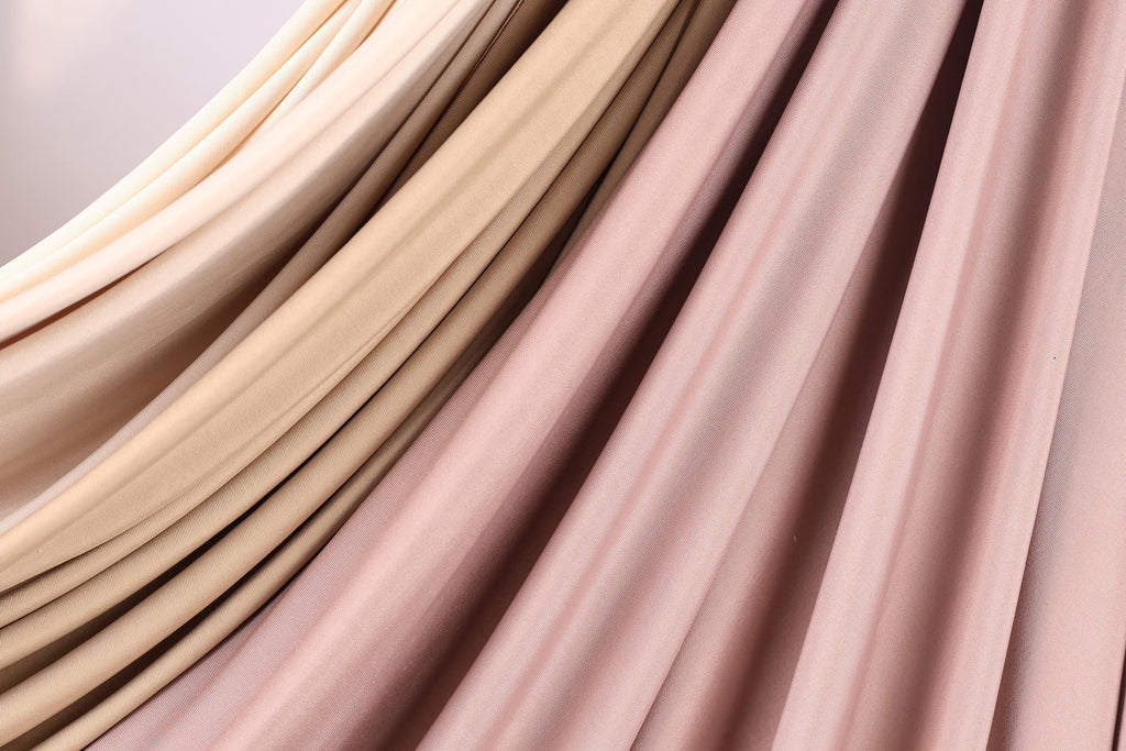 a close-up view of a fabric with a soft, flowing texture in shades of pink and beige.