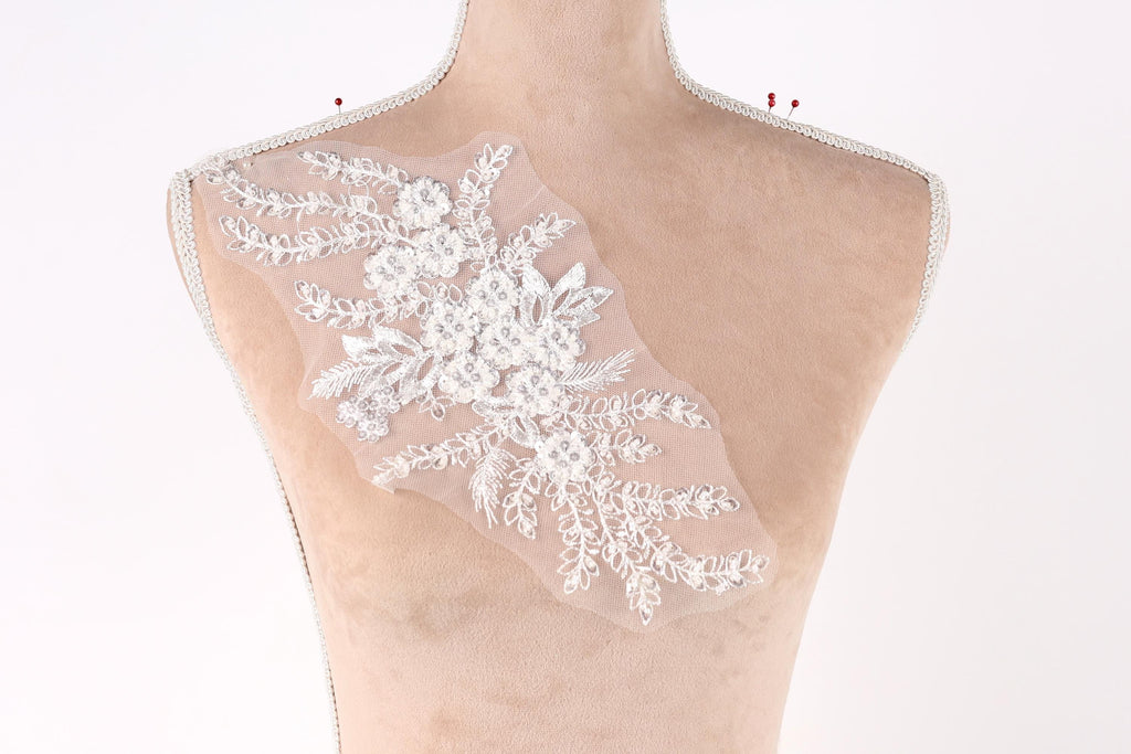 A mannequin torso with a delicate, floral-patterned fabric attached to it.