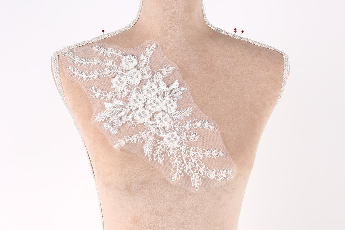 A mannequin torso with a delicate, floral-patterned fabric attached to it.