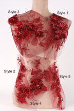 A mannequin with a red floral dress featuring various styles of embroidery and lace.