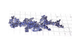 a close-up view of a piece of fabric with a floral pattern, including blue and purple flowers, and a ruler for scale.
