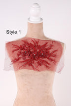 A mannequin with a red floral embellishment on its shoulder, displayed against a white background.