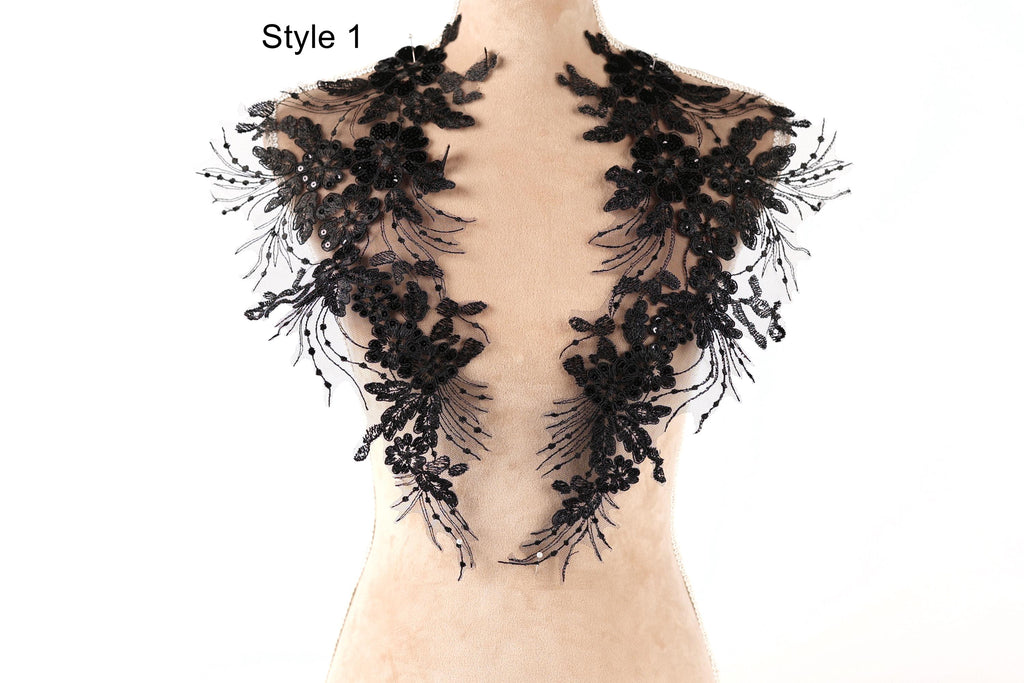 A mannequin wearing a black lace collar with intricate floral patterns.