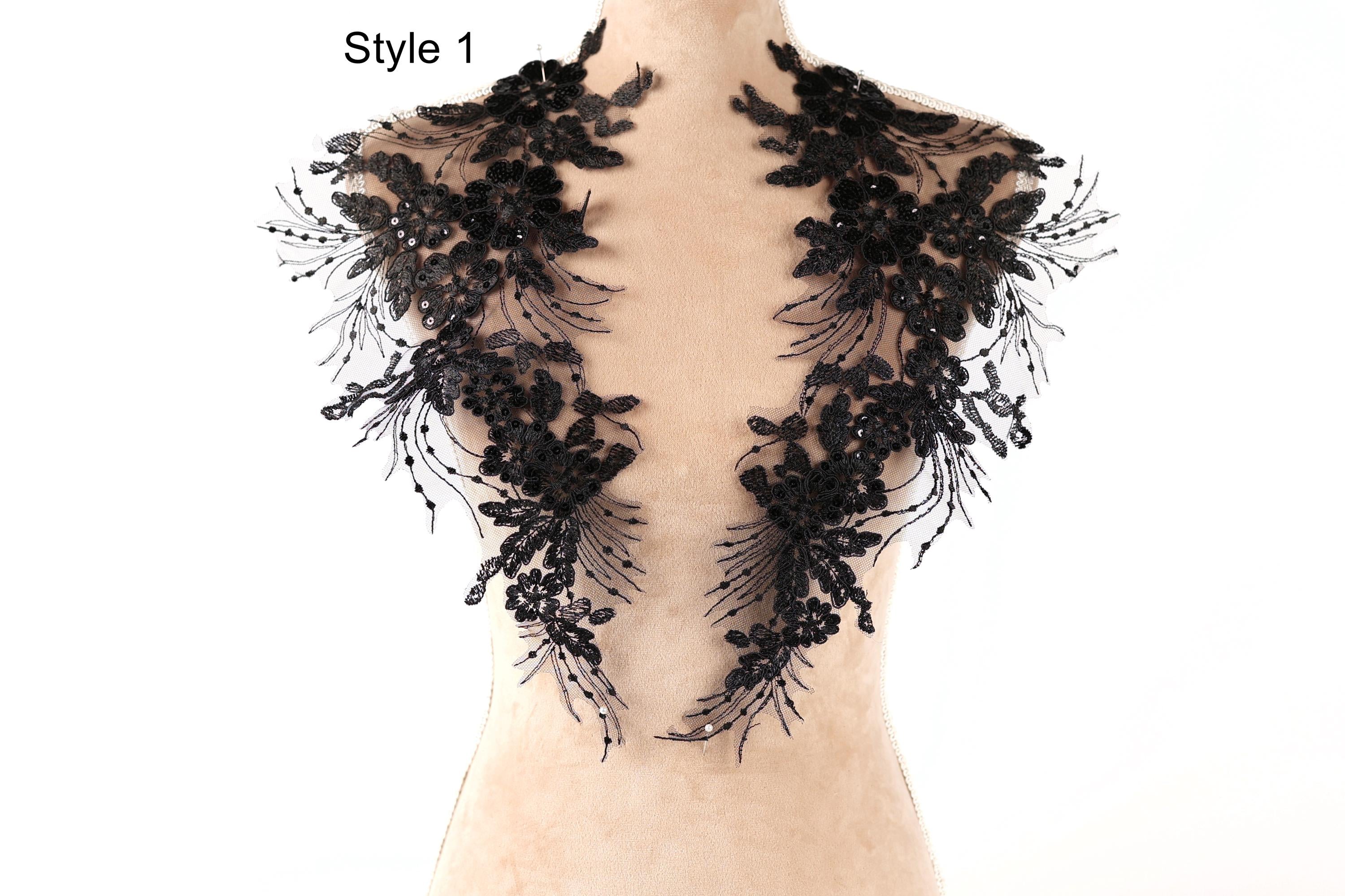 A mannequin wearing a black lace collar with intricate floral patterns.