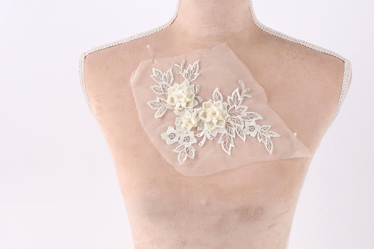 A mannequin with a delicate, white lace flower design on its bust.