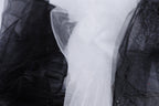 a close-up view of a black and white fabric, with the black fabric appearing more prominent in the foreground and the white fabric slightly blurred in the background.