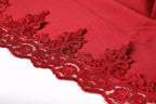 a close-up view of a red fabric with intricate red lace-like patterns along the edge, creating a visually striking and elegant design.