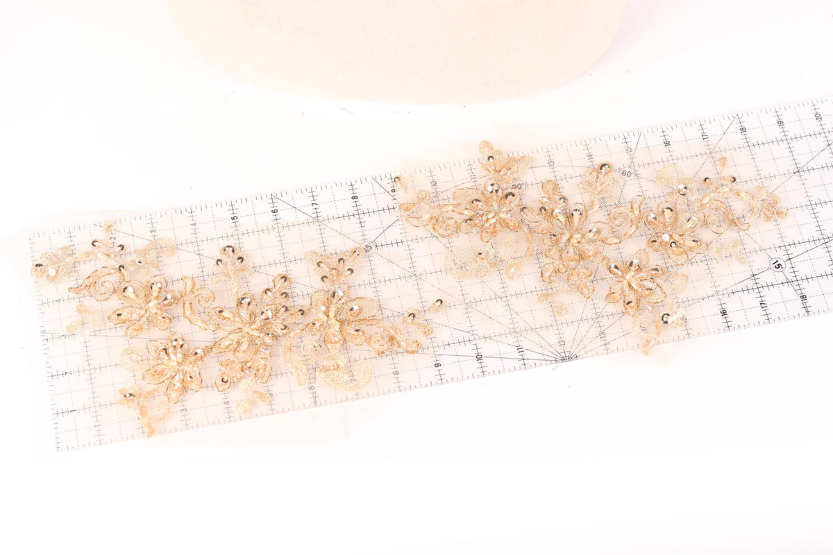 a clear ruler with gold-colored floral designs placed on it.