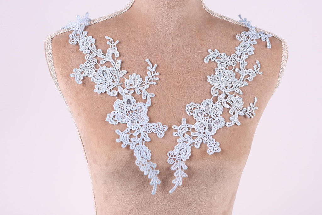 A mannequin wearing a necklace with delicate white lace pieces.