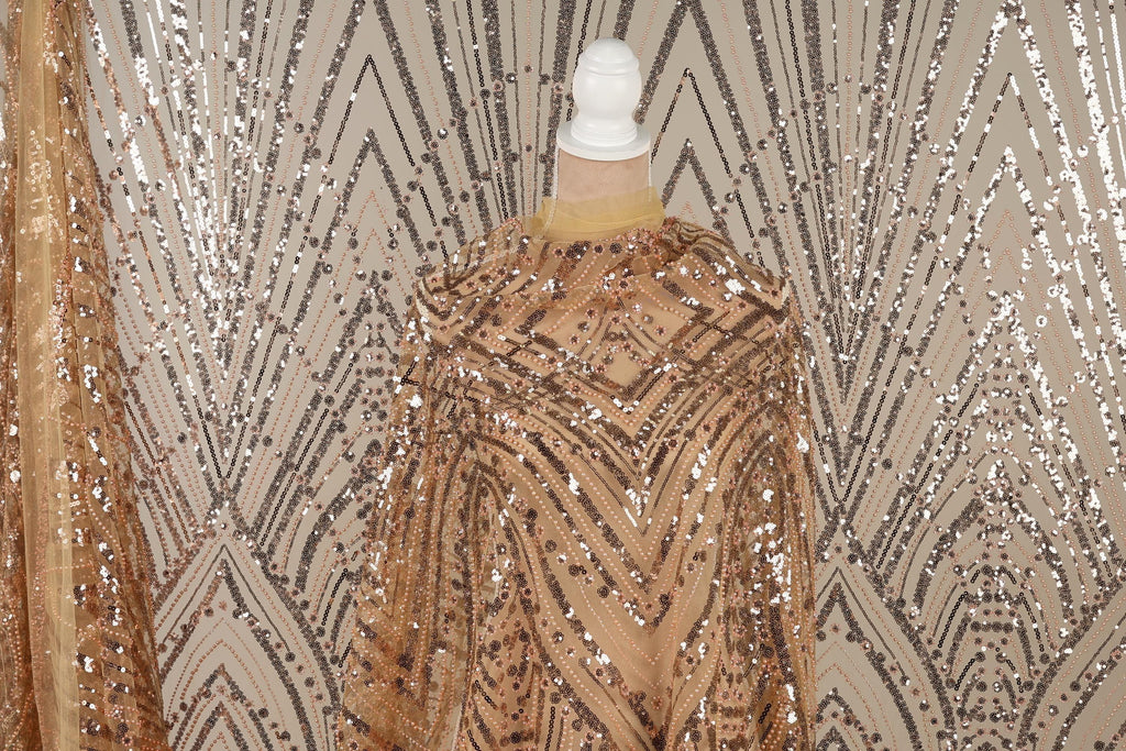 a mannequin wearing a gold sequin dress with a geometric pattern.