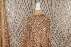 a mannequin wearing a gold sequin dress with a geometric pattern.